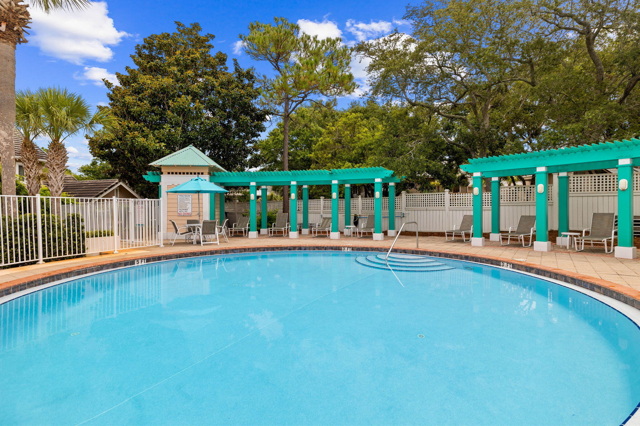 358 Rue Caribe Miramar Beach, FL 32550 - Photo 51 of 65 a view of a swimming pool with lawn chairs under an umbrella