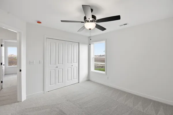 an empty room with fan and windows