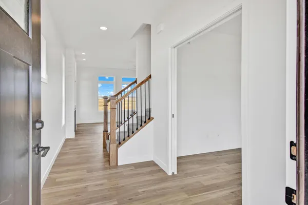 a view of a hallway with wooden floor and staircase