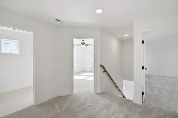 an empty room with a hallway and stairs