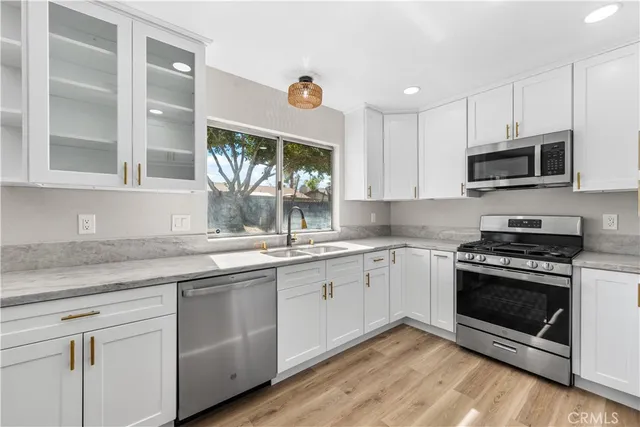 a kitchen with stainless steel appliances granite countertop a stove a sink and a microwave