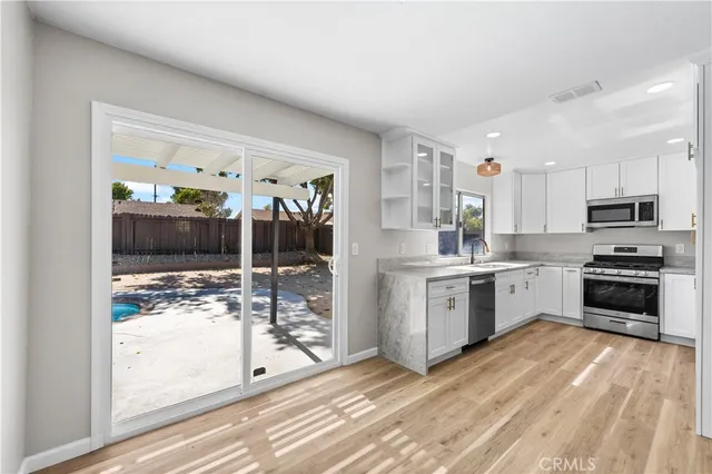a kitchen with granite countertop a refrigerator and a stove top oven
