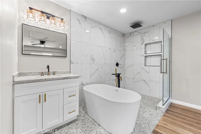 a bathroom with a bathtub shower sink mirror and toilet