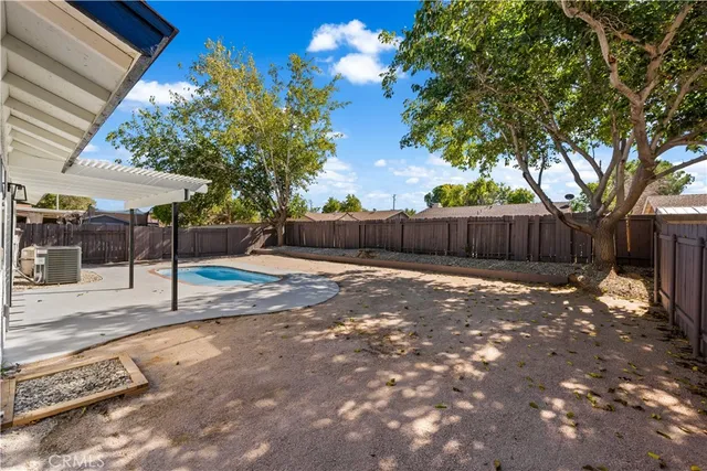 a view of a backyard with a barbeque and wooden fence