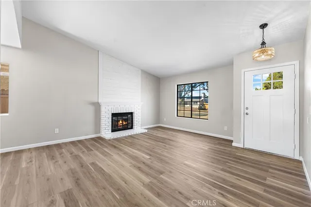 an empty room with windows and fireplace