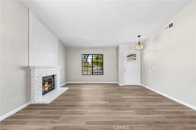 a view of an empty room with window and fire place