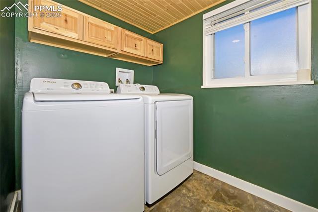 1914 Wooten Road Colorado Springs, CO 80915 - Photo 29 of 39 Washroom with wood ceiling, washing machine and dryer, and dark stone finish flooring