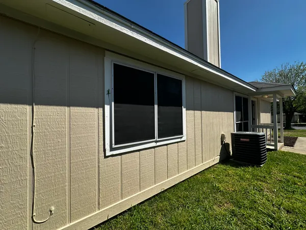a backyard of a house with barbeque oven and wooden fence