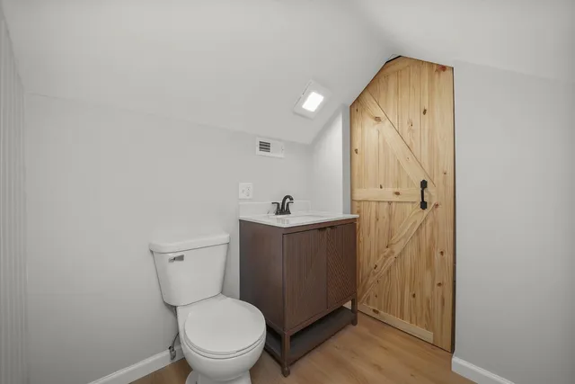 a bathroom with a toilet a sink and mirror