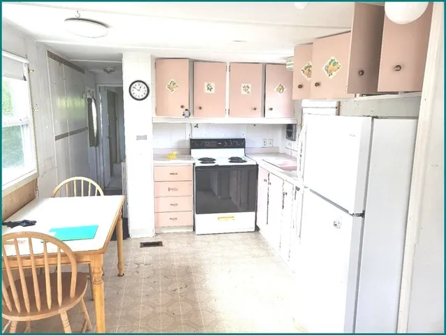 a kitchen with stainless steel appliances a refrigerator sink stove and white cabinets