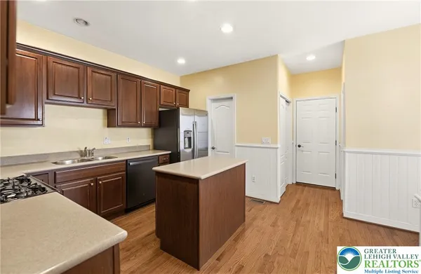 a kitchen with a sink a stove a refrigerator cabinets and wooden floor