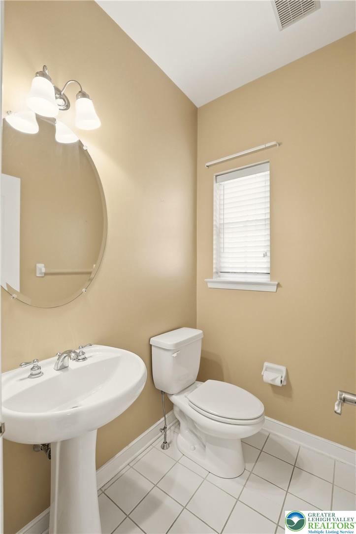 2493 Thistle Road Lower Macungie Township, PA 18062 - Photo 15 of 38 a bathroom with a sink a toilet and a mirror