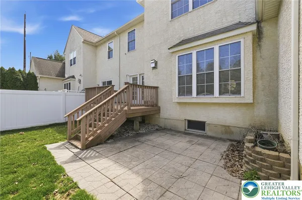 a view of a house with a small yard and a wooden deck