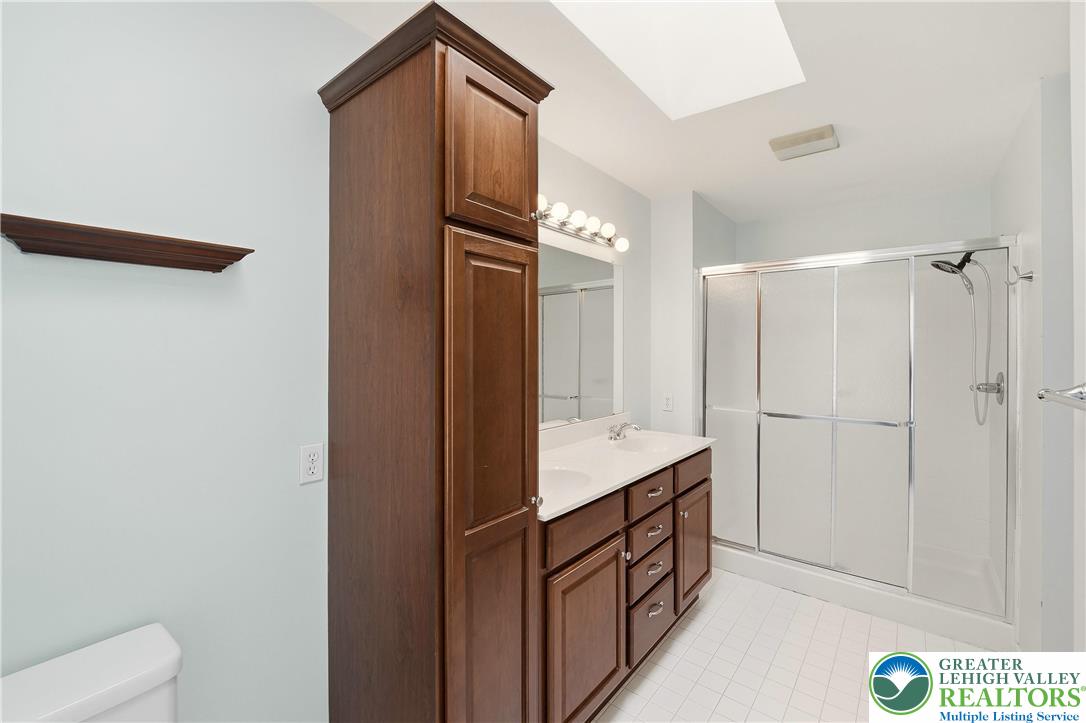 2493 Thistle Road Lower Macungie Township, PA 18062 - Photo 37 of 38 a bathroom with a double vanity sink a toilet and shower