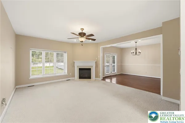 a view of an empty room with a fireplace and a window