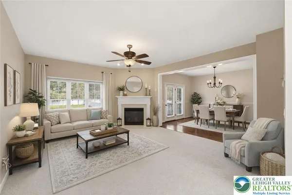 a living room with furniture a fireplace and a chandelier