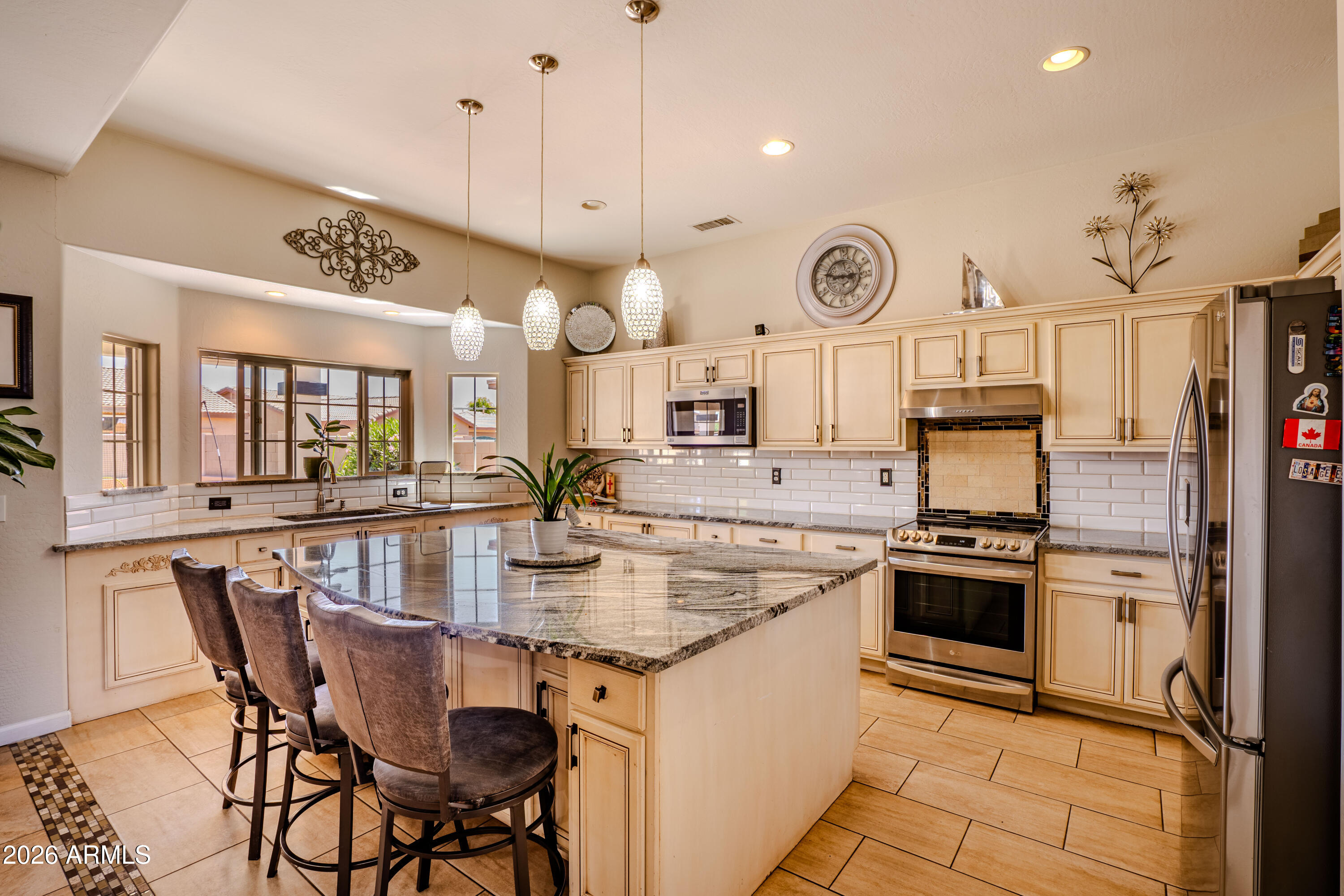 5137 West Grenadine Road Laveen, AZ 85339 - Photo 13 of 53 a kitchen with stainless steel appliances granite countertop a stove a sink dishwasher and a refrigerator with wooden floor