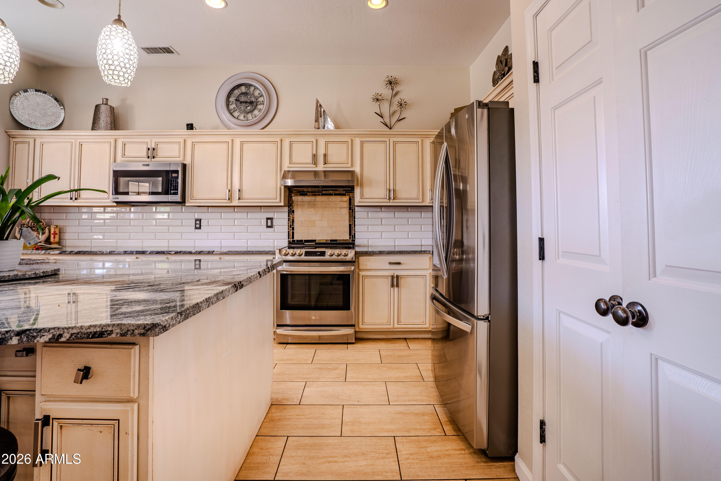 5137 West Grenadine Road Laveen, AZ 85339 - Photo 14 of 53 a kitchen with stainless steel appliances a stove a refrigerator and a cabinets