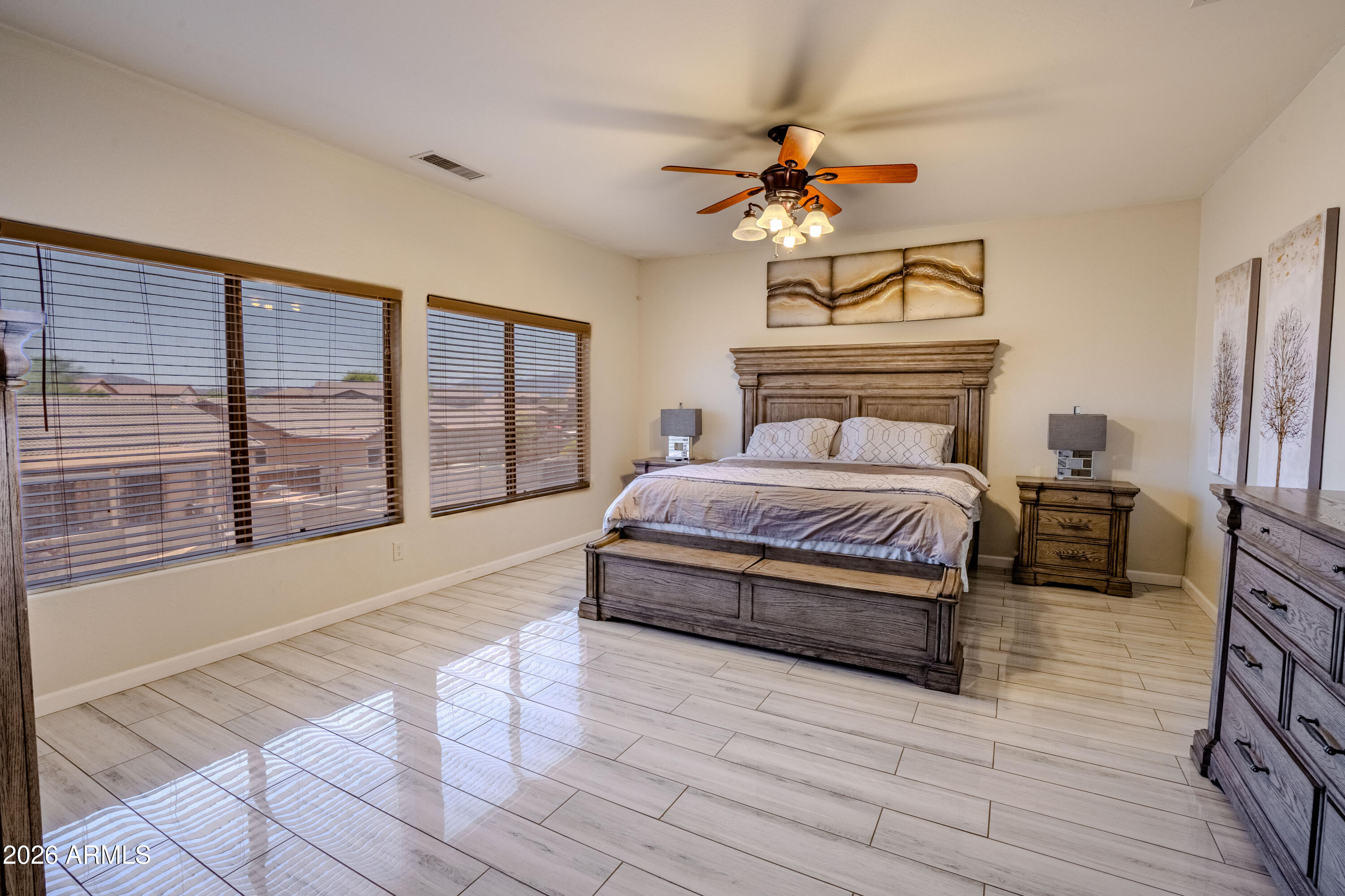5137 West Grenadine Road Laveen, AZ 85339 - Photo 32 of 53 a spacious bedroom with a large bed a chandelier and windows