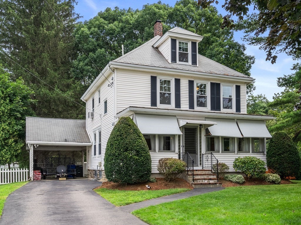 a front view of a house with a yard and potted plants