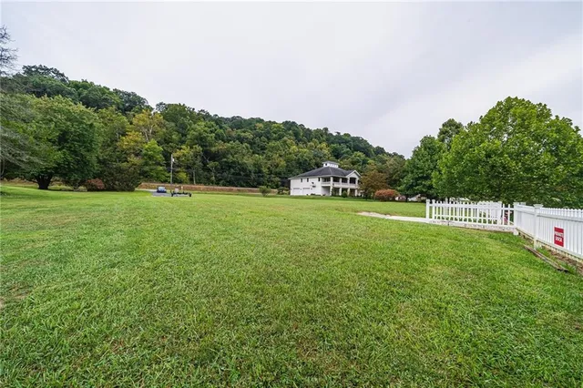 a view of a green field with wooden fence