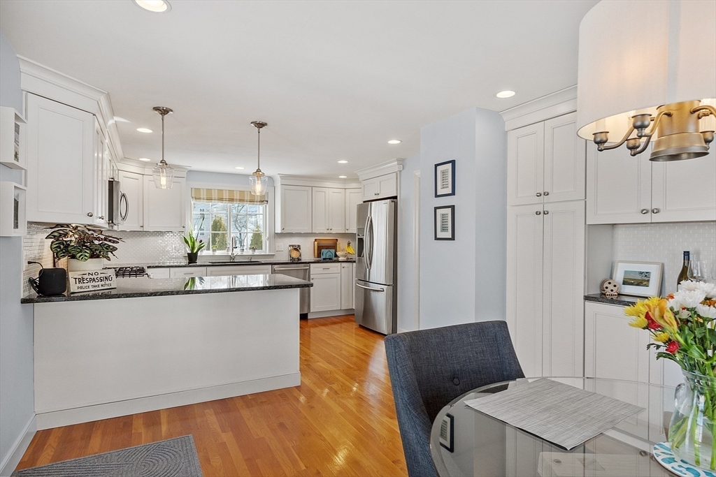 88 Menotomy Road Arlington, MA 02476 - Photo 11 of 40 a kitchen with stainless steel appliances granite countertop a refrigerator a sink a stove and white cabinets