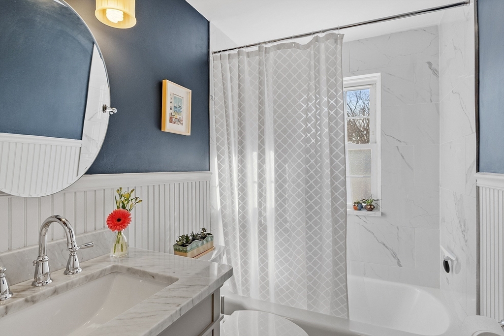 88 Menotomy Road Arlington, MA 02476 - Photo 21 of 40 a bathroom with a granite countertop sink and a shower curtain