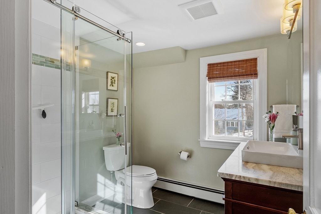 88 Menotomy Road Arlington, MA 02476 - Photo 27 of 40 a bathroom with a granite countertop sink toilet a mirror and shower