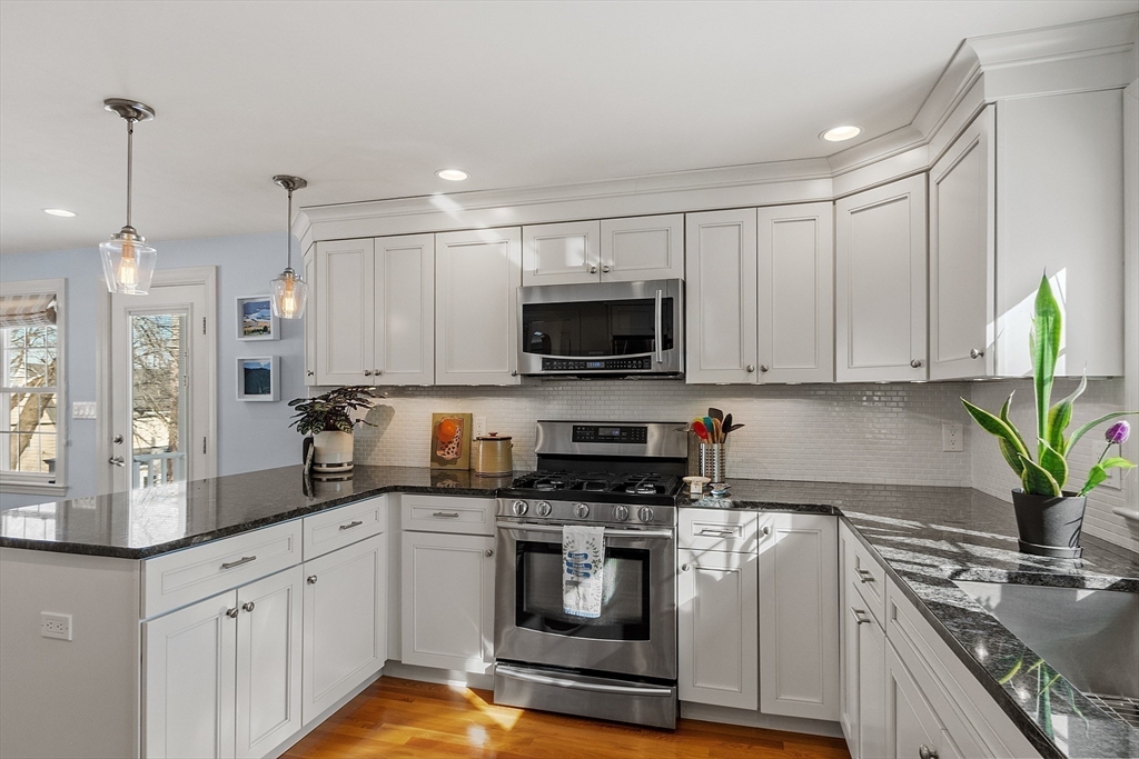 88 Menotomy Road Arlington, MA 02476 - Photo 5 of 40 a kitchen with granite countertop white cabinets and stainless steel appliances
