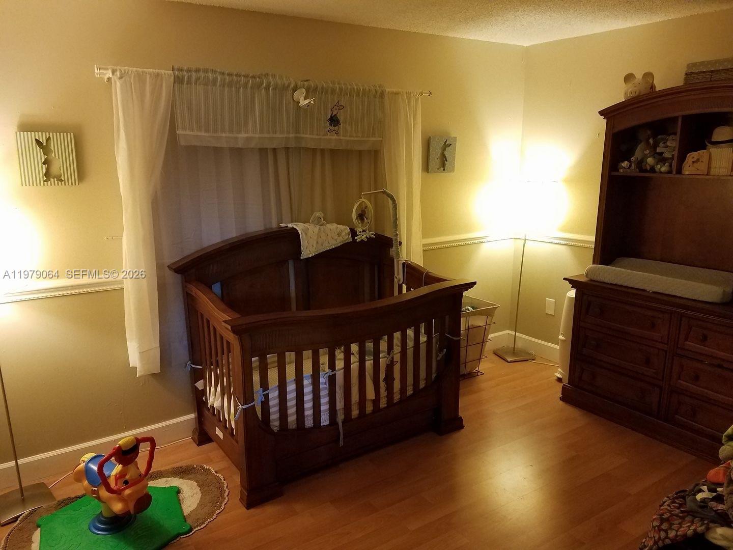 8500 Southwest 133rd Avenue Road, Unit 108 Miami, FL 33183 - Photo 13 of 17 a bedroom with a bed and wooden floor