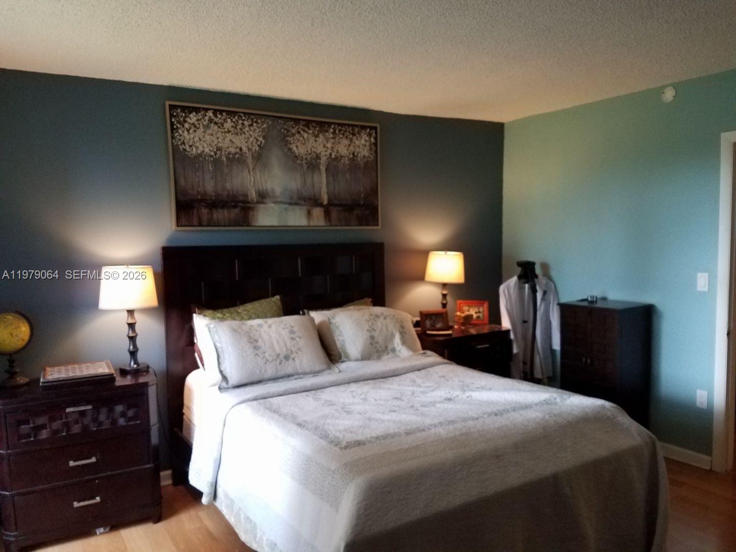 8500 Southwest 133rd Avenue Road, Unit 108 Miami, FL 33183 - Photo 14 of 17 a bedroom with a bed and lamp on dresser