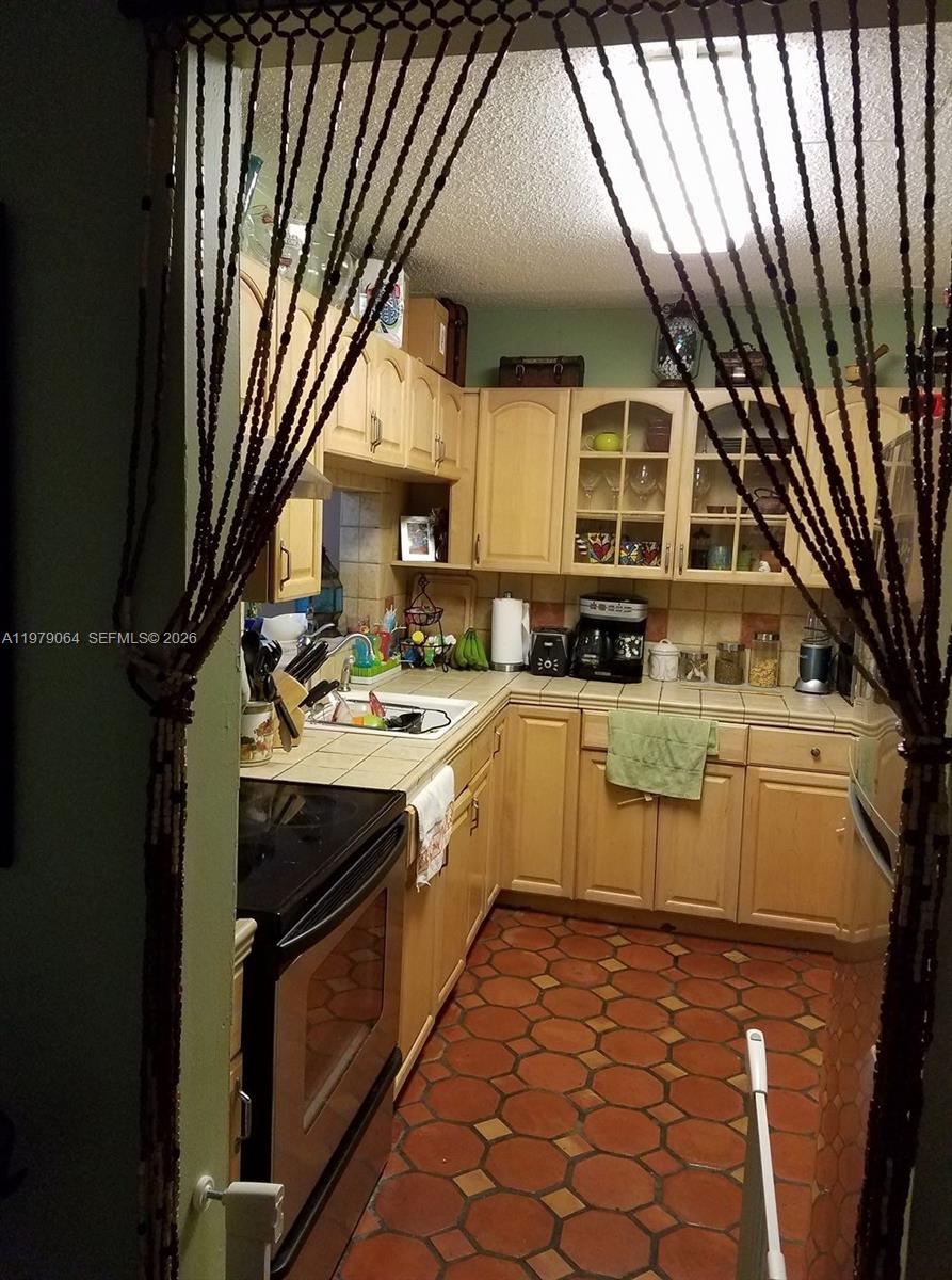 8500 Southwest 133rd Avenue Road, Unit 108 Miami, FL 33183 - Photo 4 of 17 a kitchen with stainless steel appliances granite countertop a stove a sink and a refrigerator