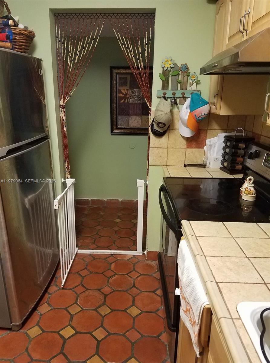 8500 Southwest 133rd Avenue Road, Unit 108 Miami, FL 33183 - Photo 5 of 17 a kitchen with a refrigerator and a stove