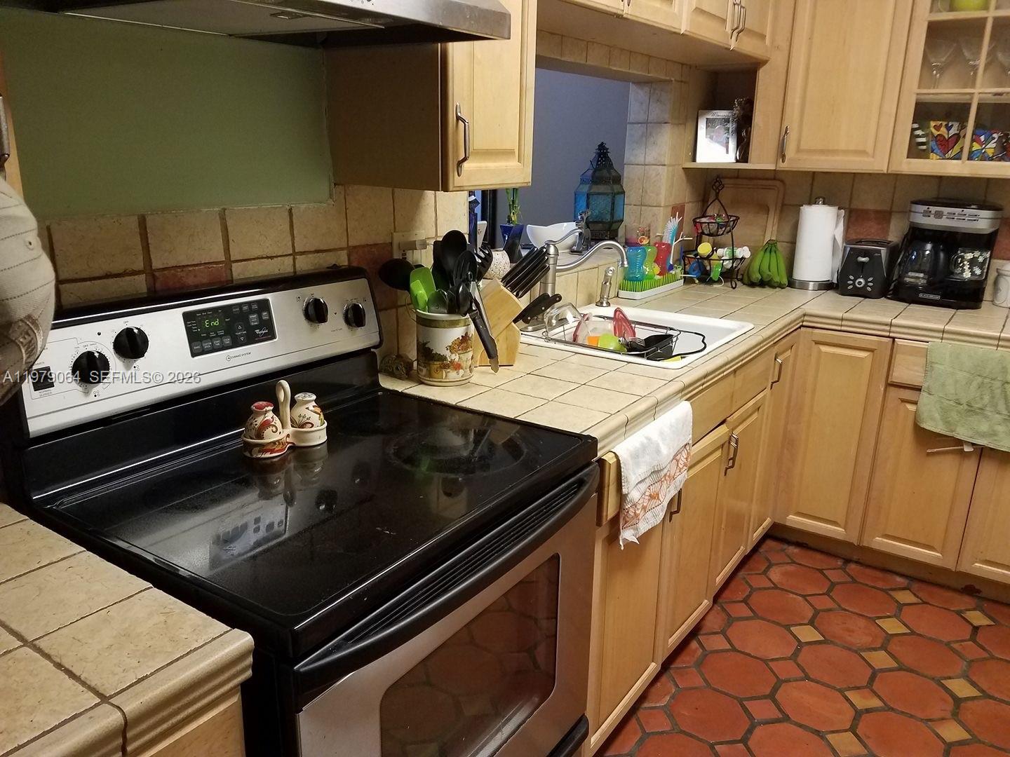 8500 Southwest 133rd Avenue Road, Unit 108 Miami, FL 33183 - Photo 6 of 17 a kitchen with a stove and a sink