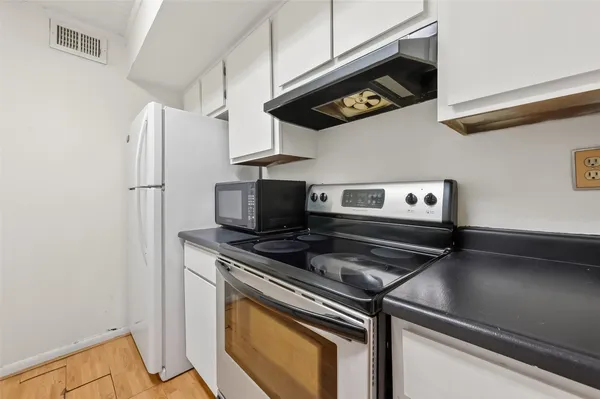 a kitchen with stainless steel appliances granite countertop a sink a stove and a refrigerator