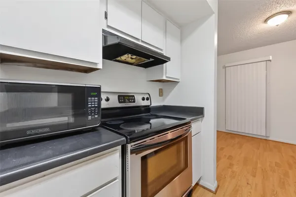 a kitchen with stainless steel appliances granite countertop a stove and a microwave