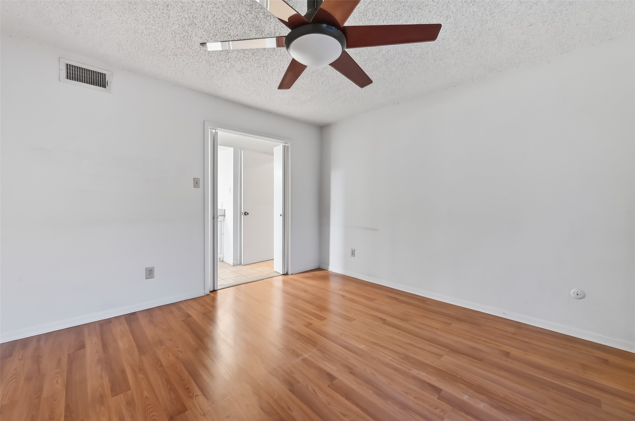 2800 Jeanetta Street, Unit 2003 Houston, TX 77063 - Photo 17 of 24 an empty room with wooden floor ceiling fan and windows