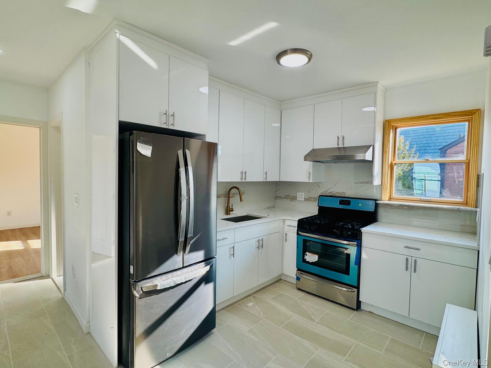 a kitchen with stainless steel appliances granite countertop a refrigerator and a sink