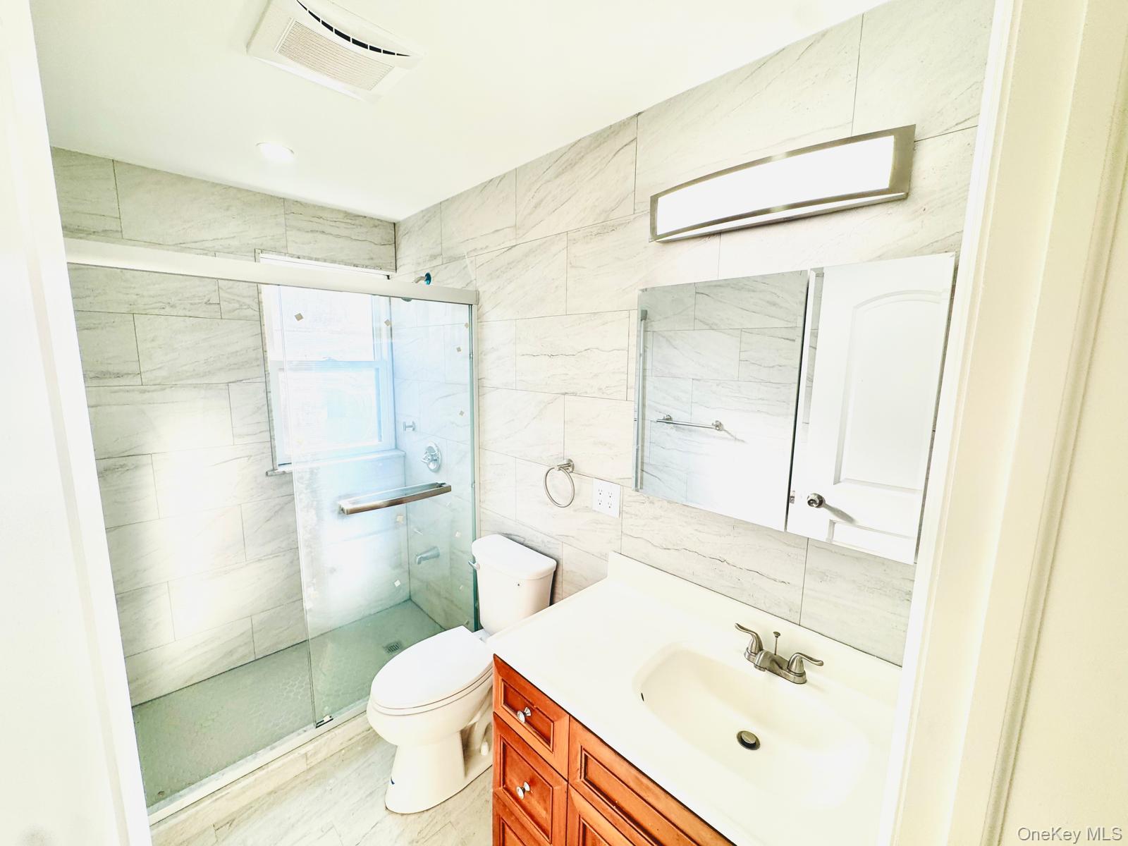 63-87 Fitchett Street, Unit 2 Queens, NY 11374 - Photo 11 of 12 a bathroom with a sink a toilet and shower