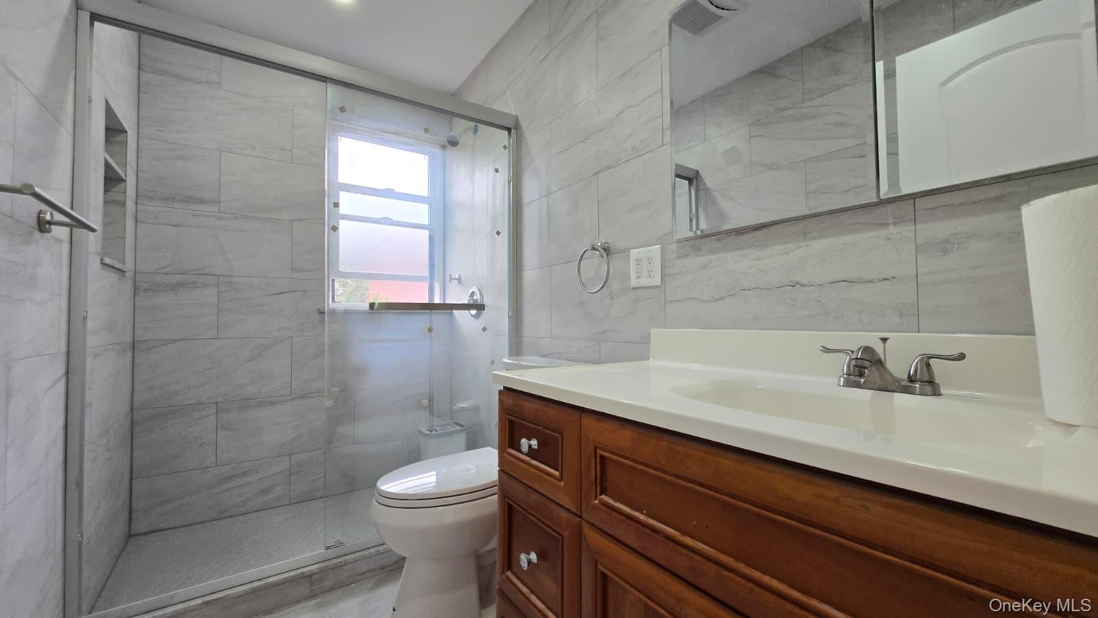 63-87 Fitchett Street, Unit 2 Queens, NY 11374 - Photo 12 of 12 a bathroom with a sink a toilet and shower