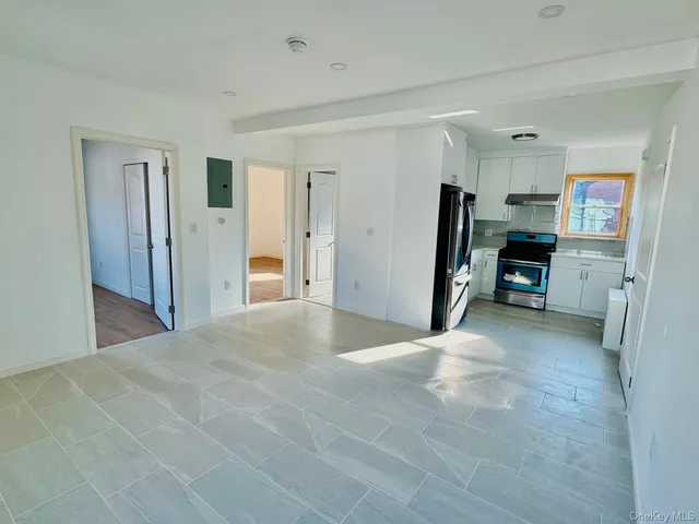 a view of a kitchen with refrigerator and window