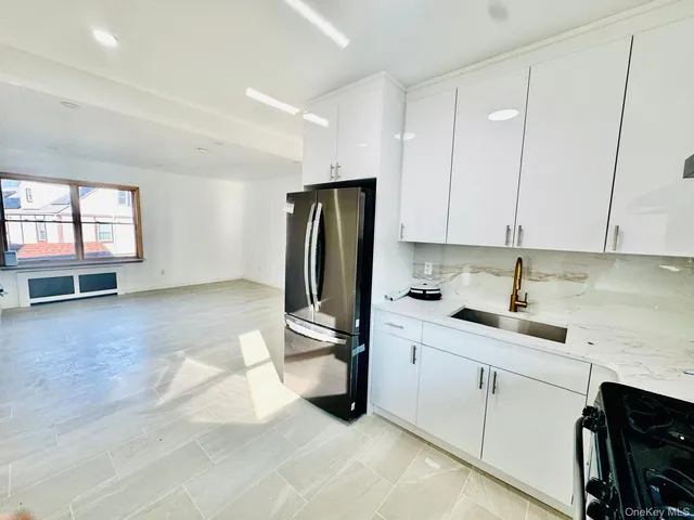 a kitchen with a sink a refrigerator and cabinets