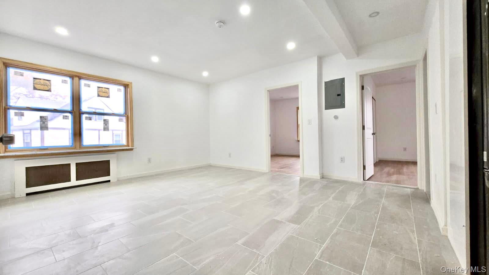 63-87 Fitchett Street, Unit 2 Queens, NY 11374 - Photo 7 of 12 a view of an empty room with a window and kitchen view