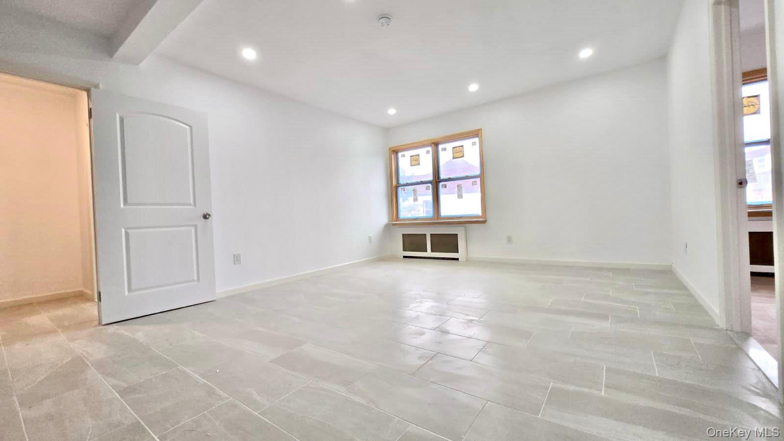 63-87 Fitchett Street, Unit 2 Queens, NY 11374 - Photo 9 of 12 an empty room with windows and pillars in it