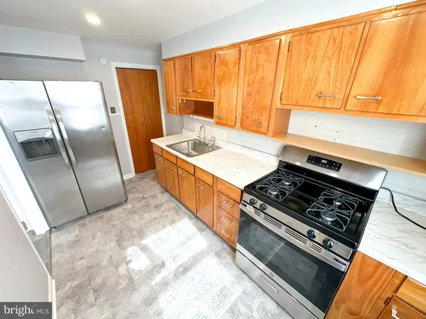 a kitchen with stainless steel appliances a stove a sink and a refrigerator