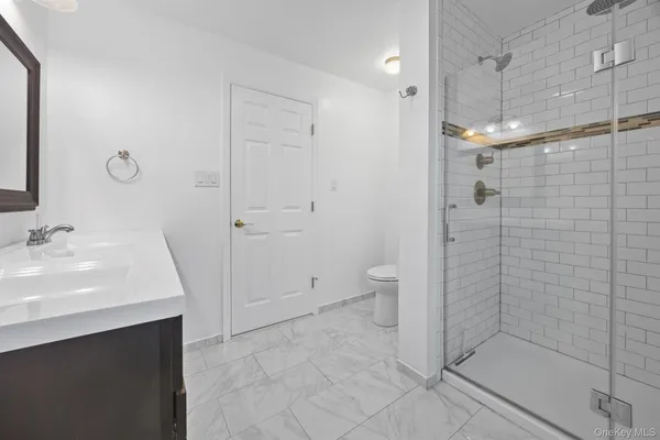 a bathroom with a sink a toilet and shower
