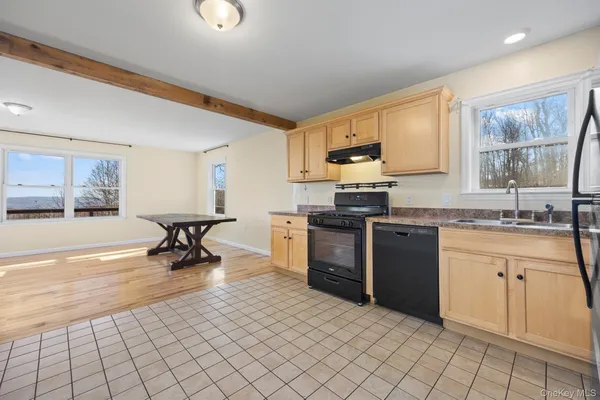 a kitchen with granite countertop a sink cabinets and stainless steel appliances