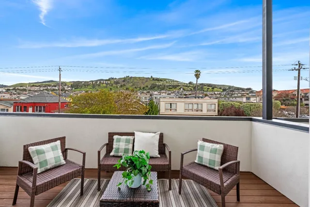 a view of a chairs and table in a balcony