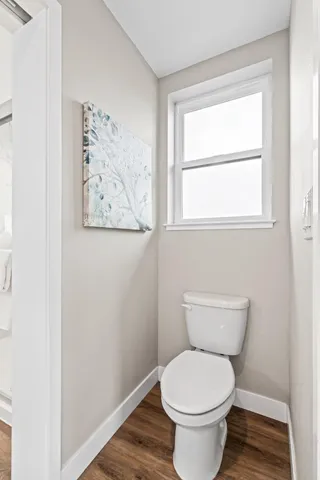 a white toilet sitting next to a window