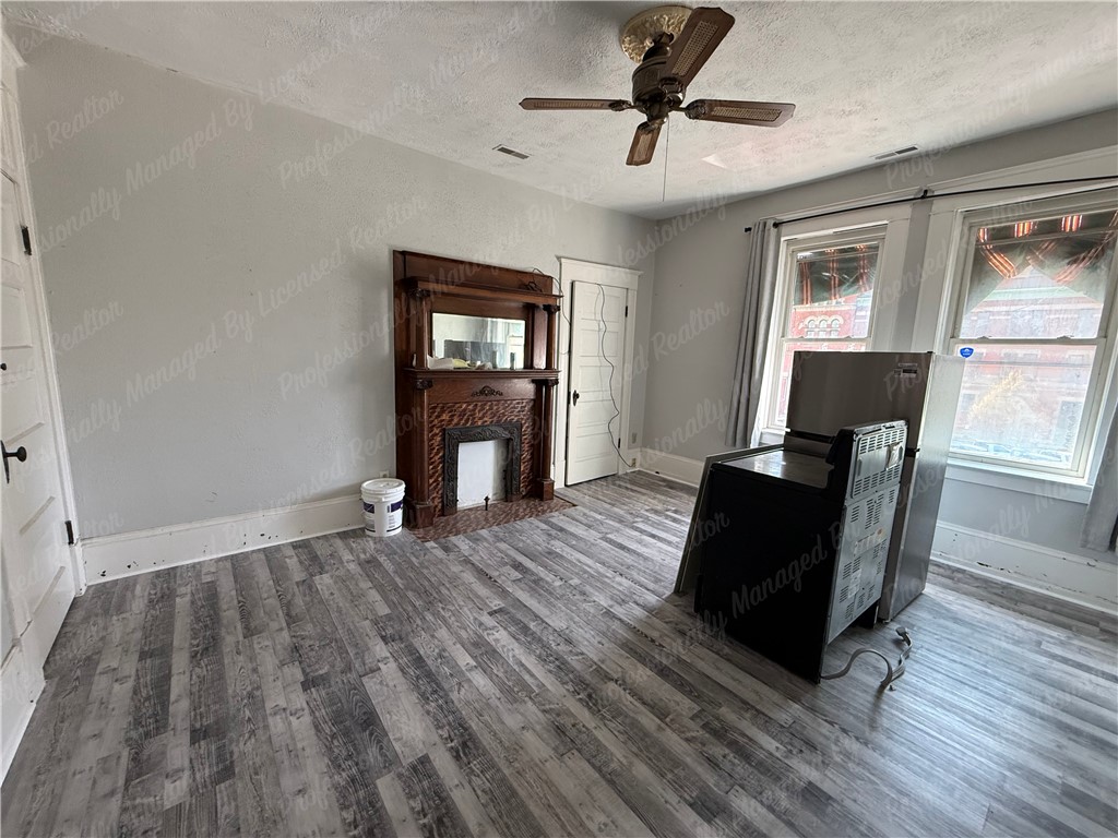 44 West High Street, Unit D Springfield, OH 45502 - Photo 6 of 25 This versatile room features elegant flooring and a classic fireplace, awaiting your personal touch.